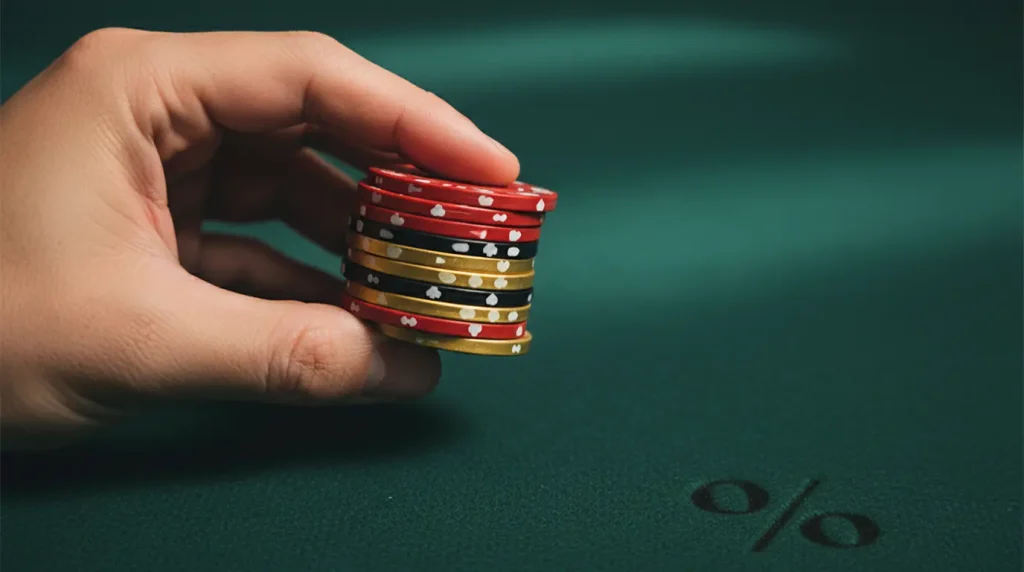 A hand holding casino chips with a percentage symbol nearby representing cashback offers